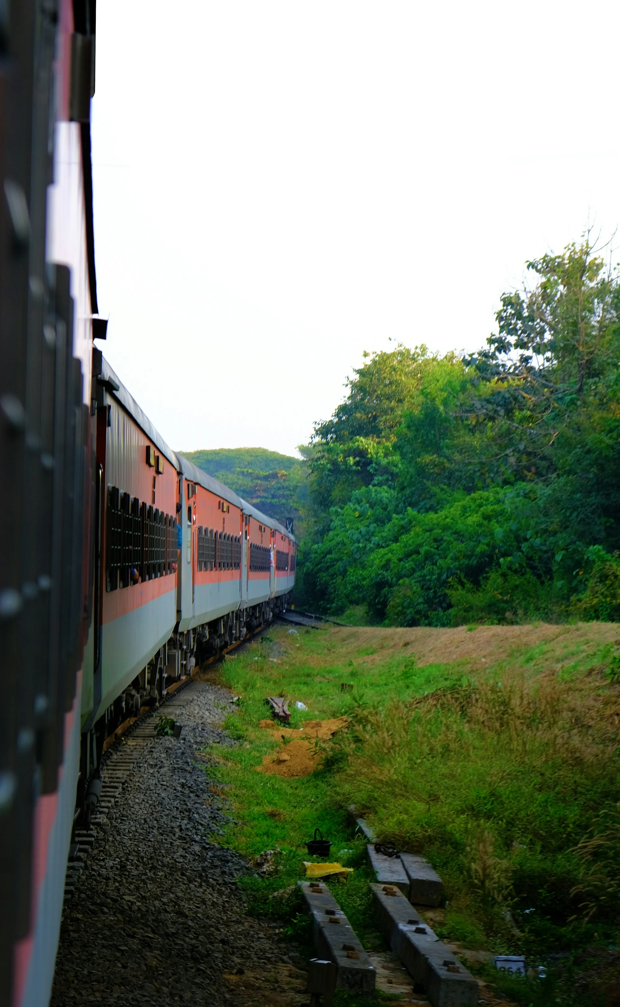 A train curving through green hills
